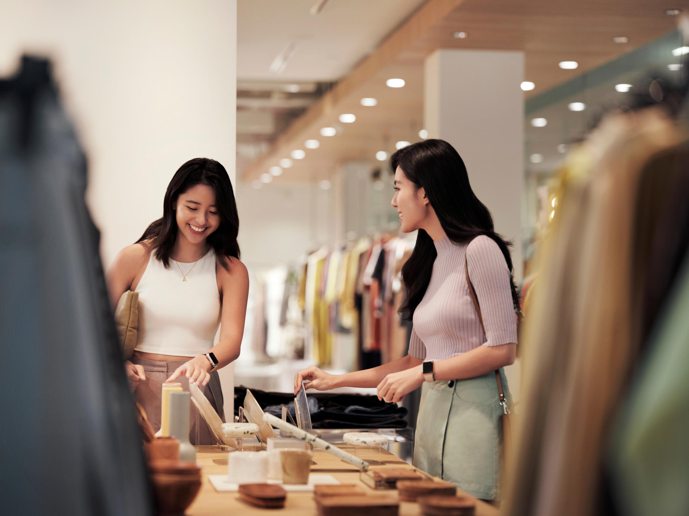 Woman shopping and paying inside a clothing and fashion store for apparel.