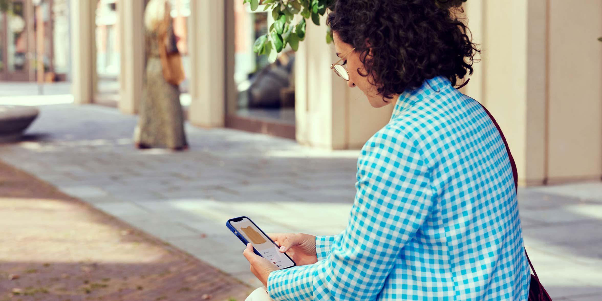 Person beim Einkaufen auf ihrem Telefon