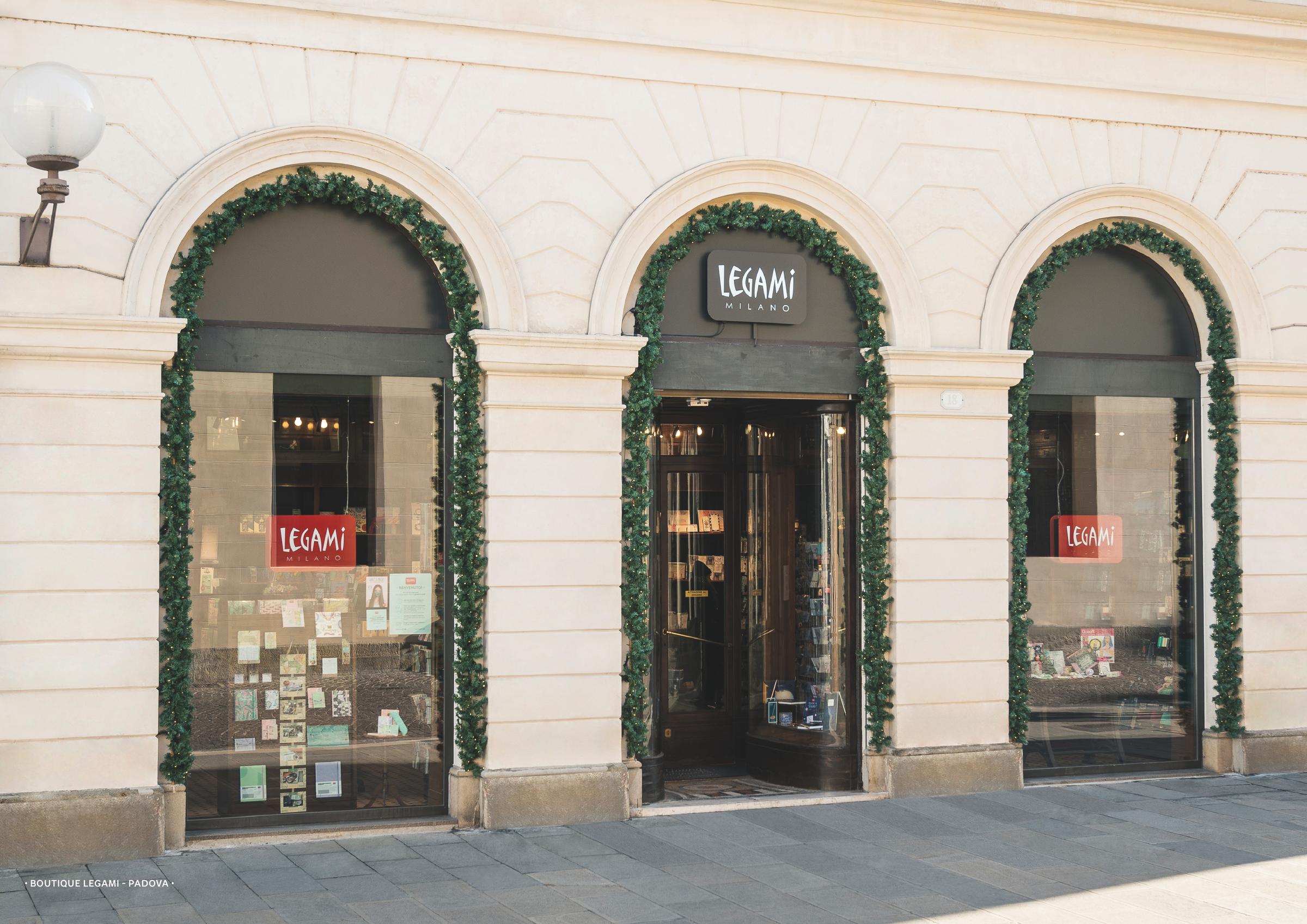 Vista esterna del negozio LEGAMI Milano con verde intorno alle finestre ad arco.