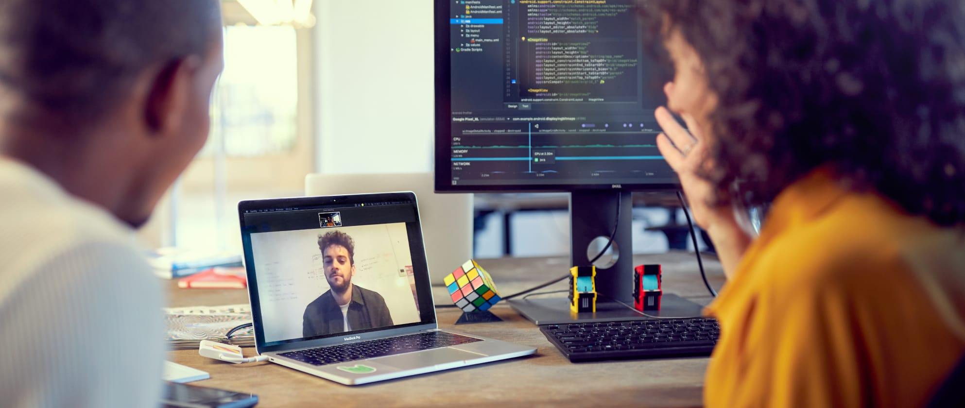 Zwei Menschen sprechen mit einer Person über einen Videochat