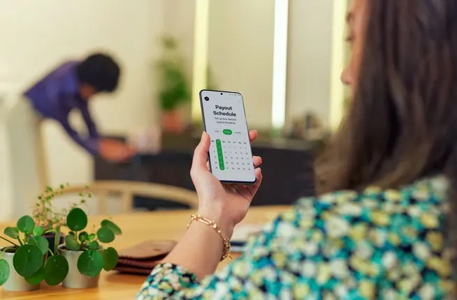 Person on phone looking at payout schedule