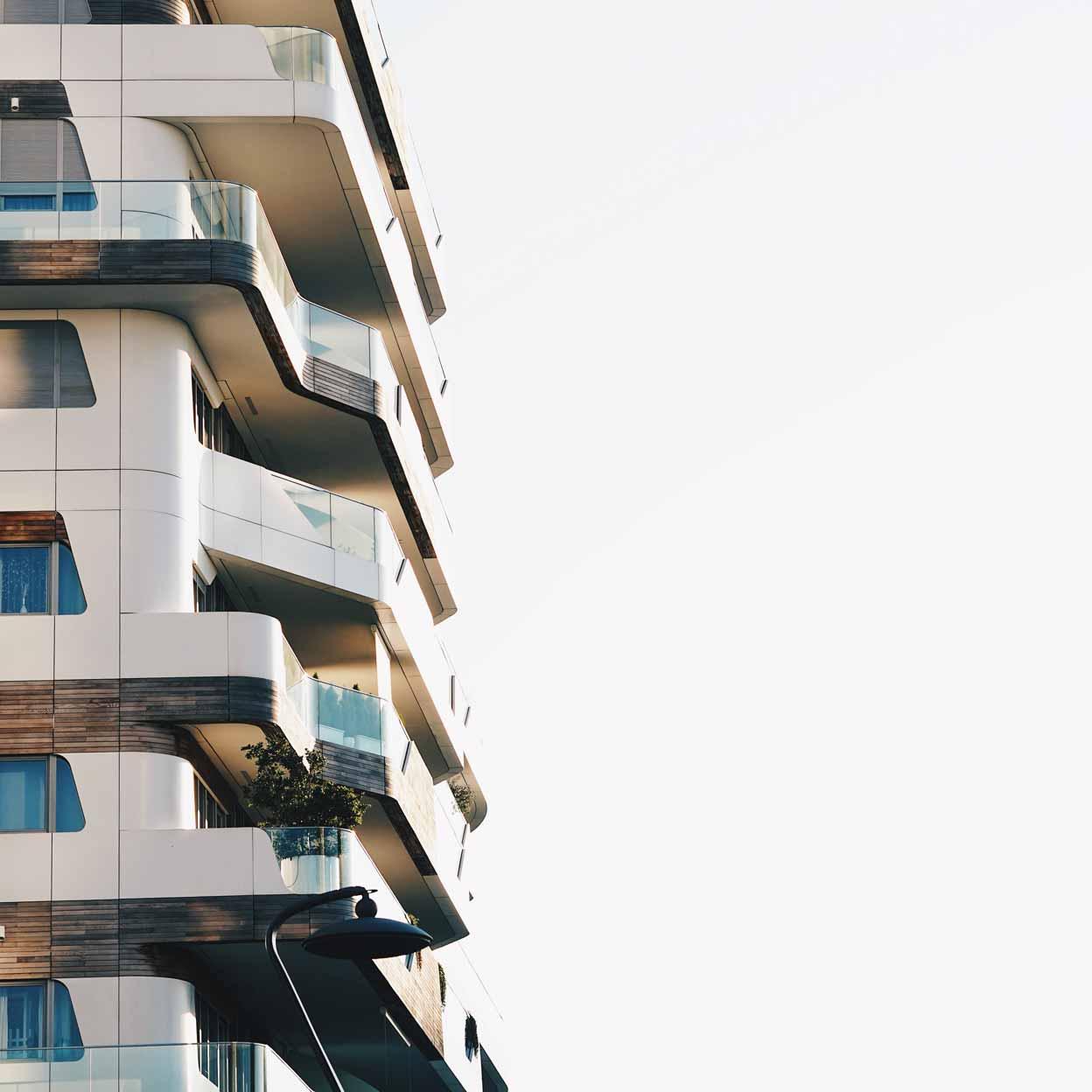 Modern residential building with curved balconies and clear sky.