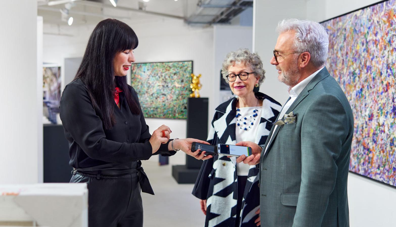 Couple making contactless payment at art gallery