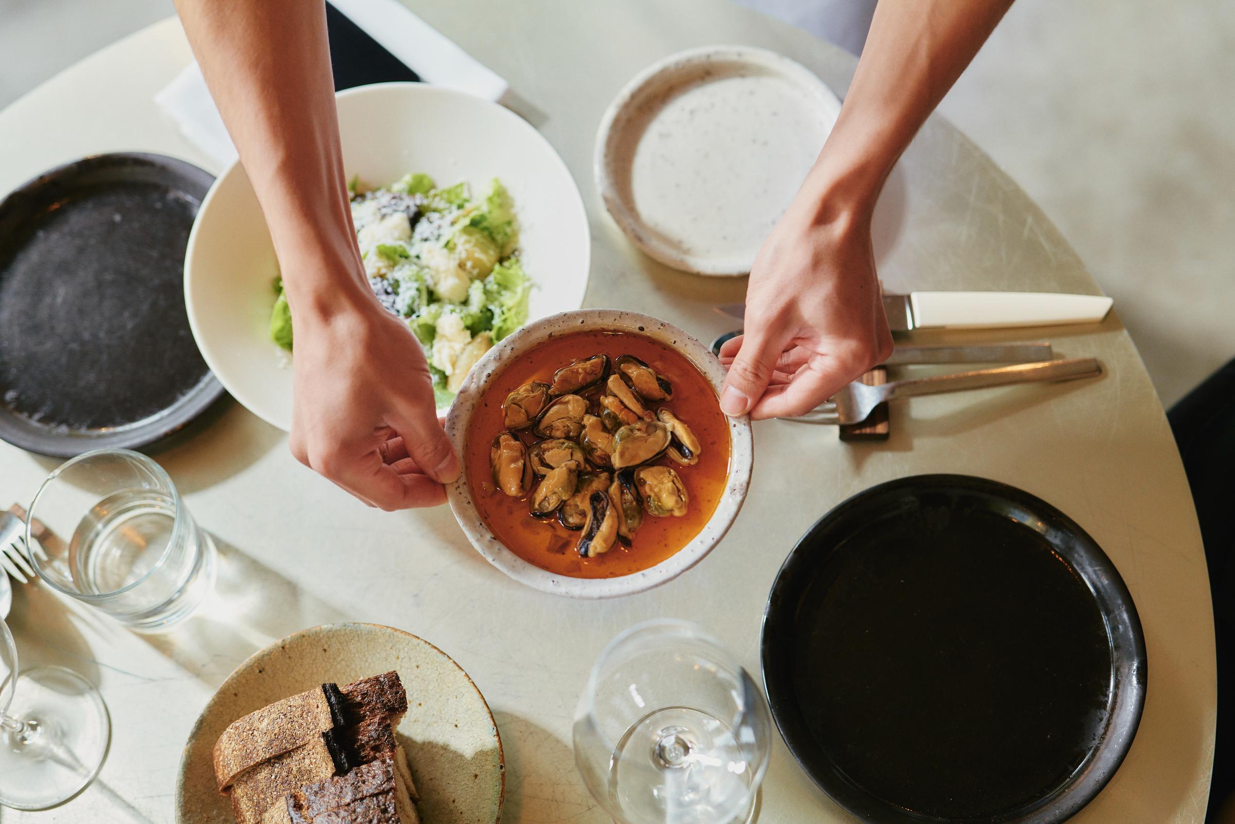 A bowl of seafood being served at a table in a restaurant.