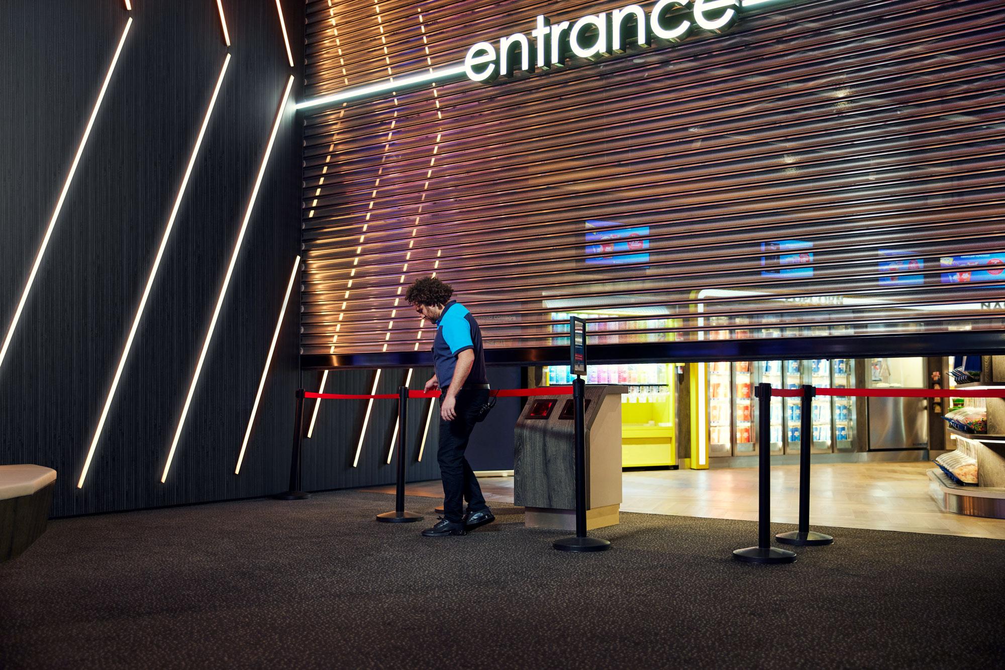 Cinema employee preparing the entrance for opening.