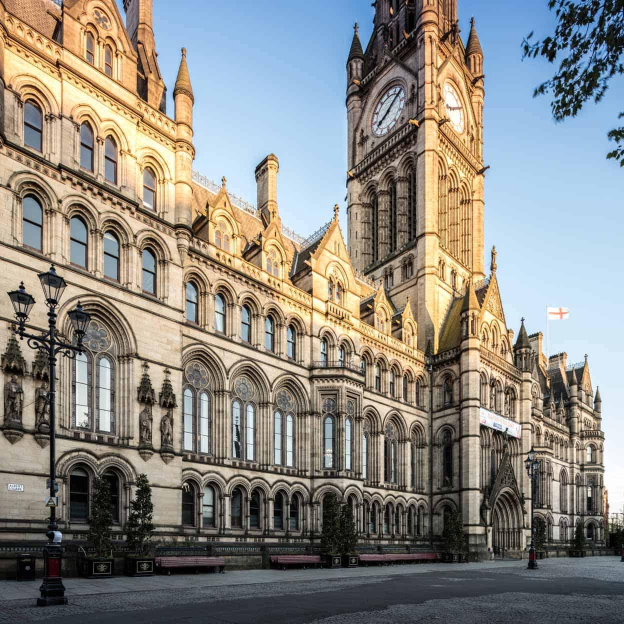 Historic gothic-style town hall with a clock tower under a clear sky.