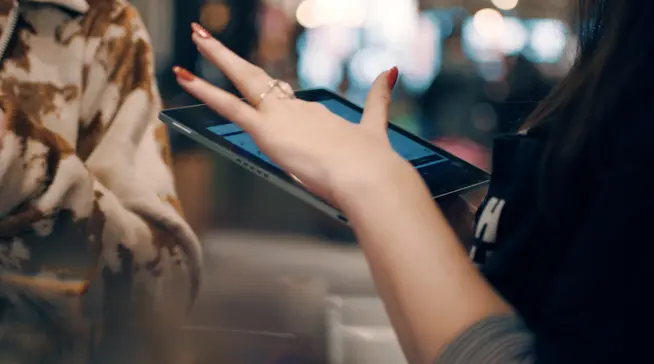 Close-up of hands using a tablet payment terminal.