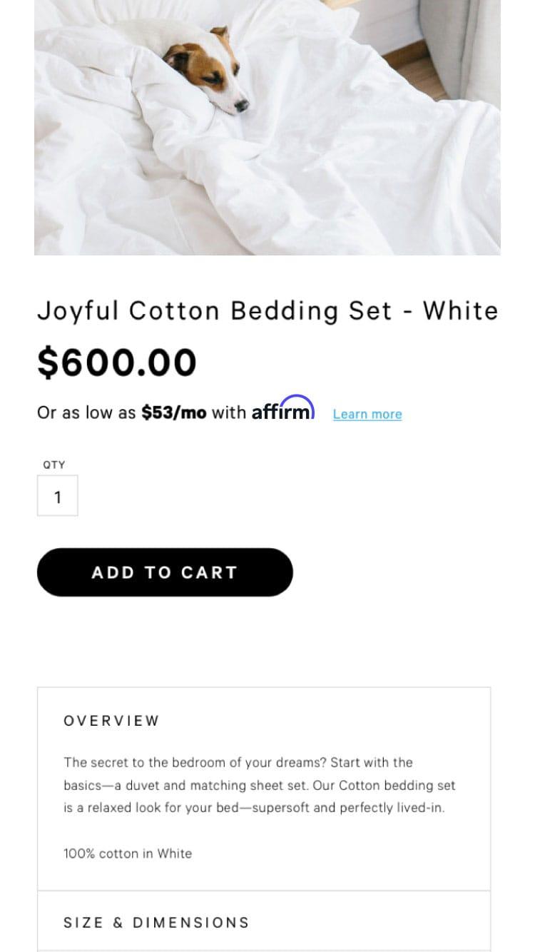 Small dog resting in a white cotton bedding set displayed on a web page with product details and price.