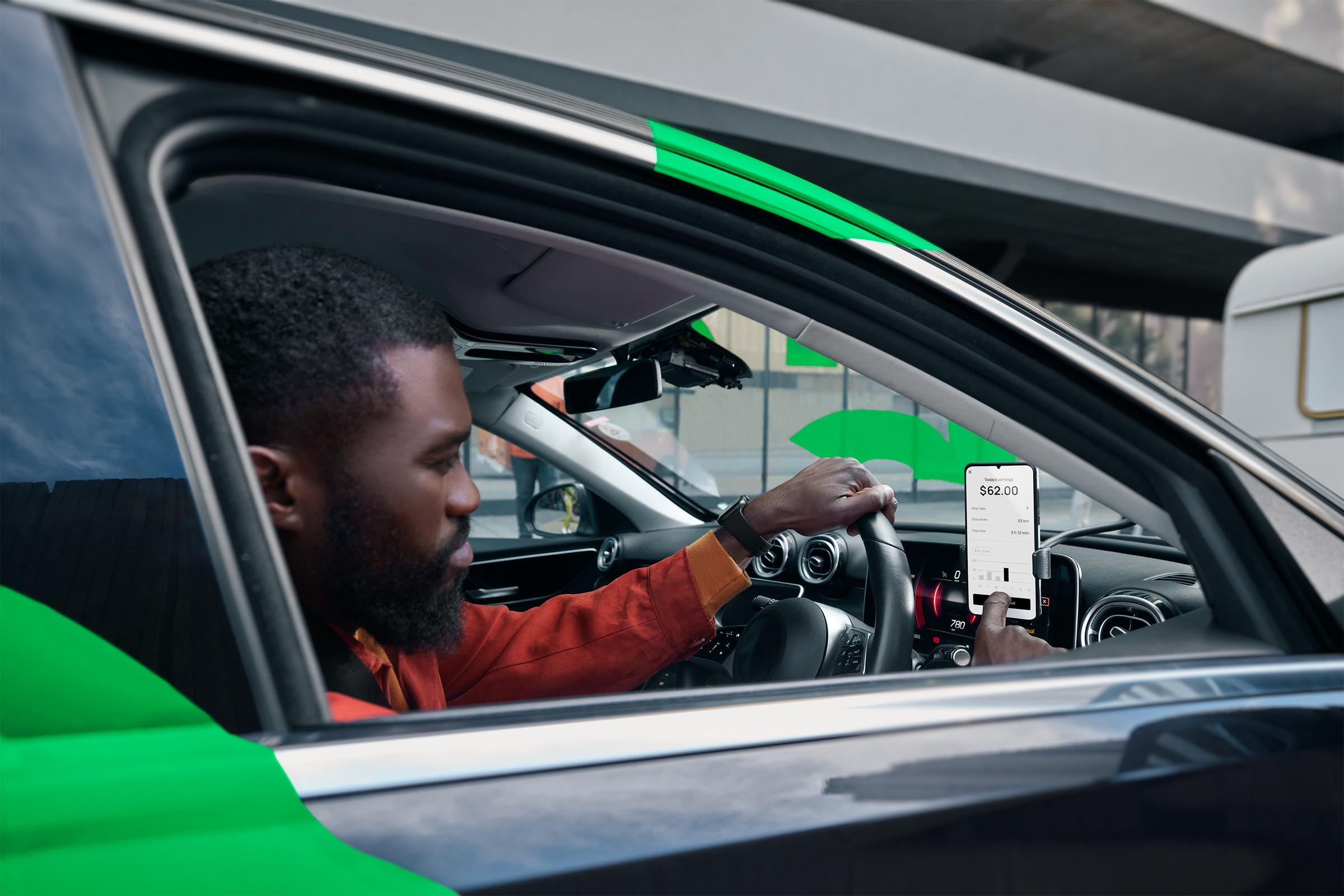 Driver viewing ride hailing app in car