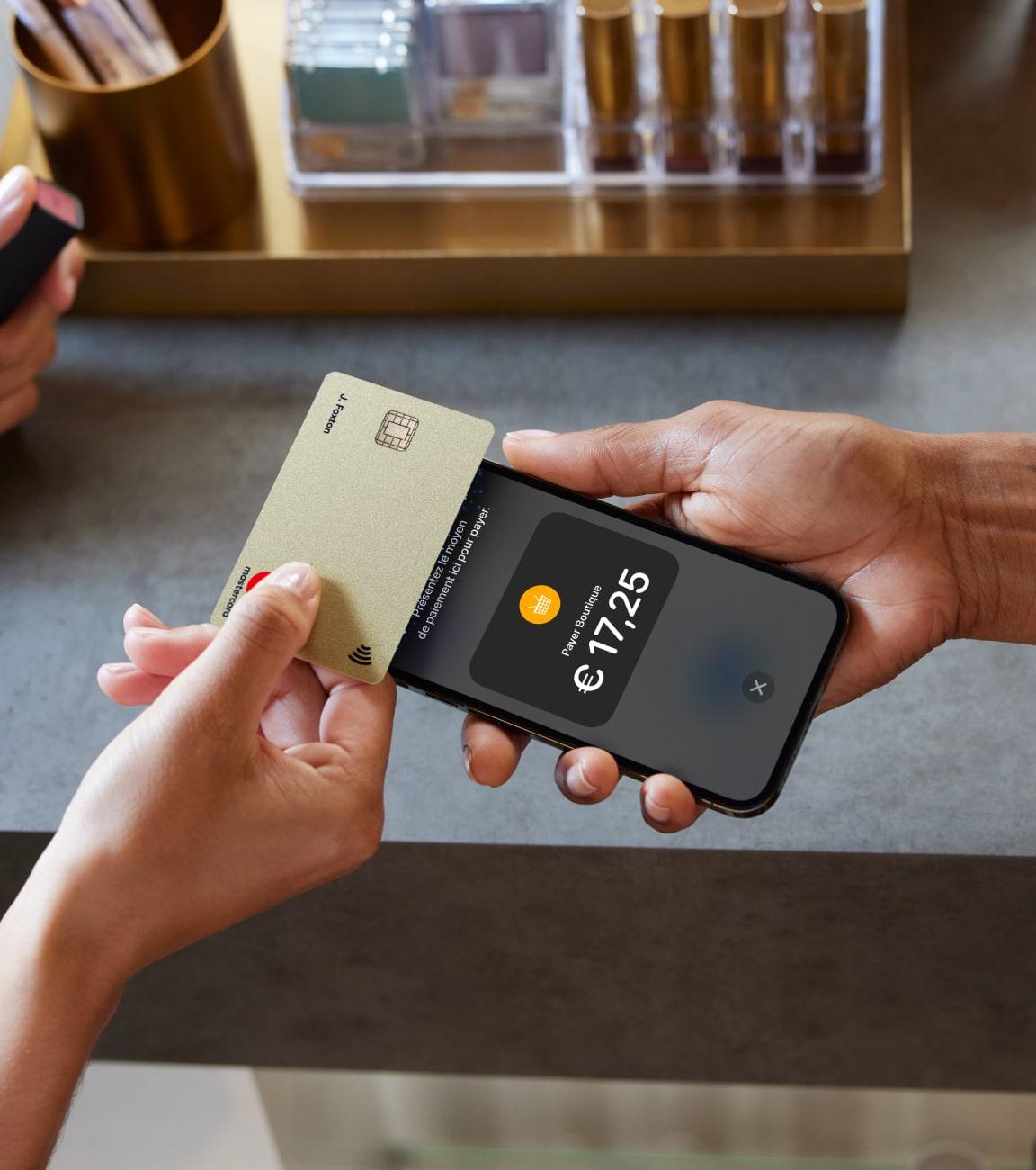 Mains tenant une carte de crédit et un smartphone affichant un paiement de €17.25 avec l’interface Adyen.