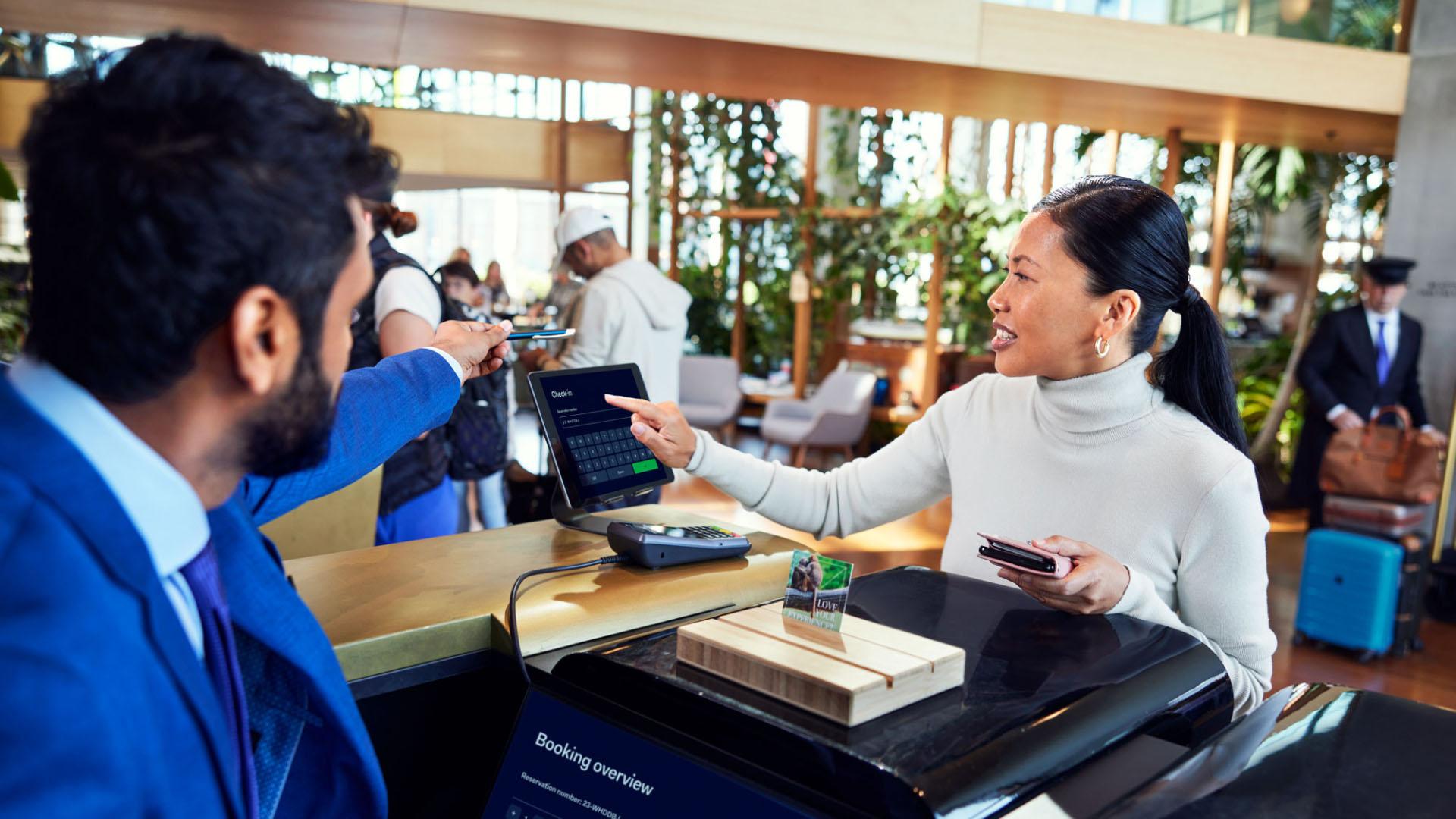 Hotellreceptionist hjälper gäst med Adyen-betaltillstånd