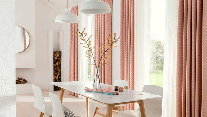 Bright dining room with a modern wooden table, white chairs, and decorative pendant lights.