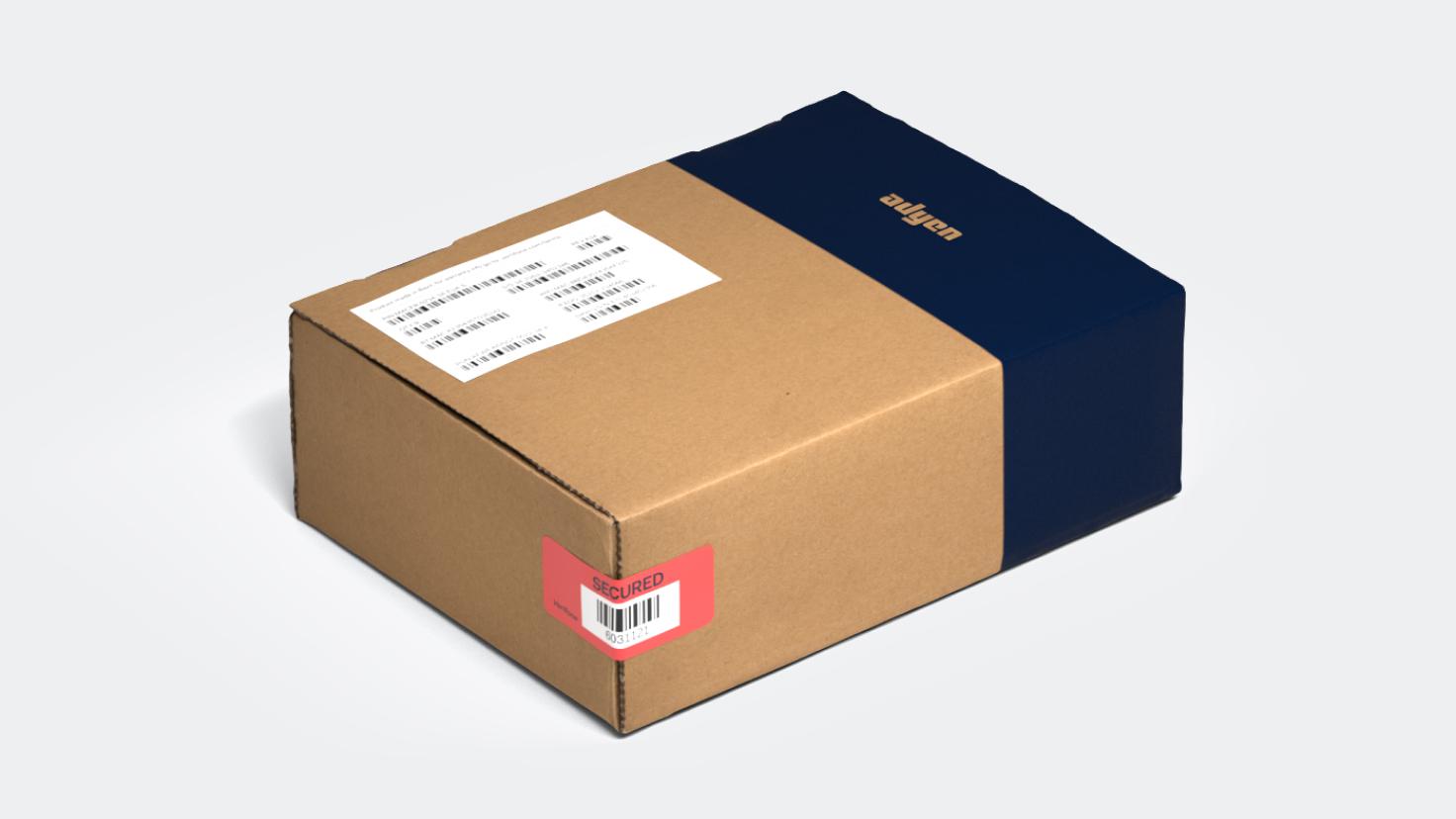 Cardboard box with blue Adyen branding and secured label.