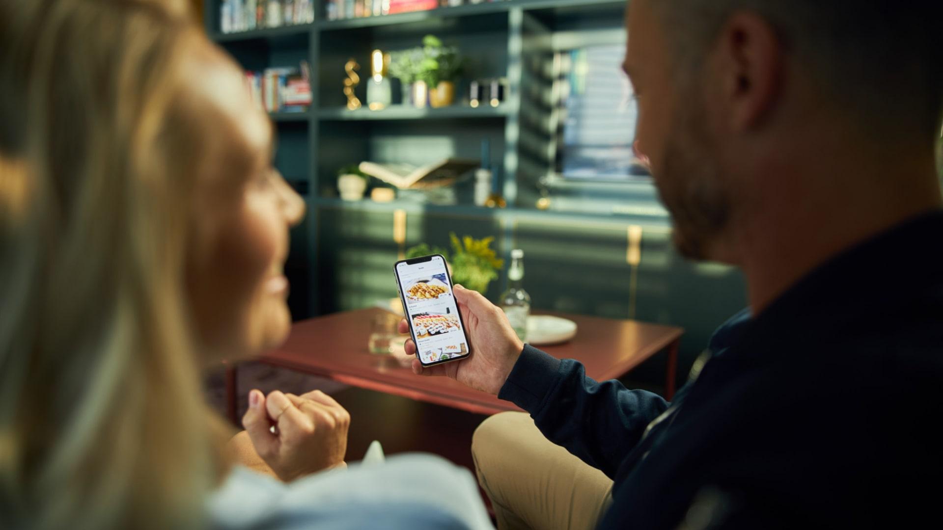 Twee mensen die naar een mobiele betaalapp op een smartphone kijken