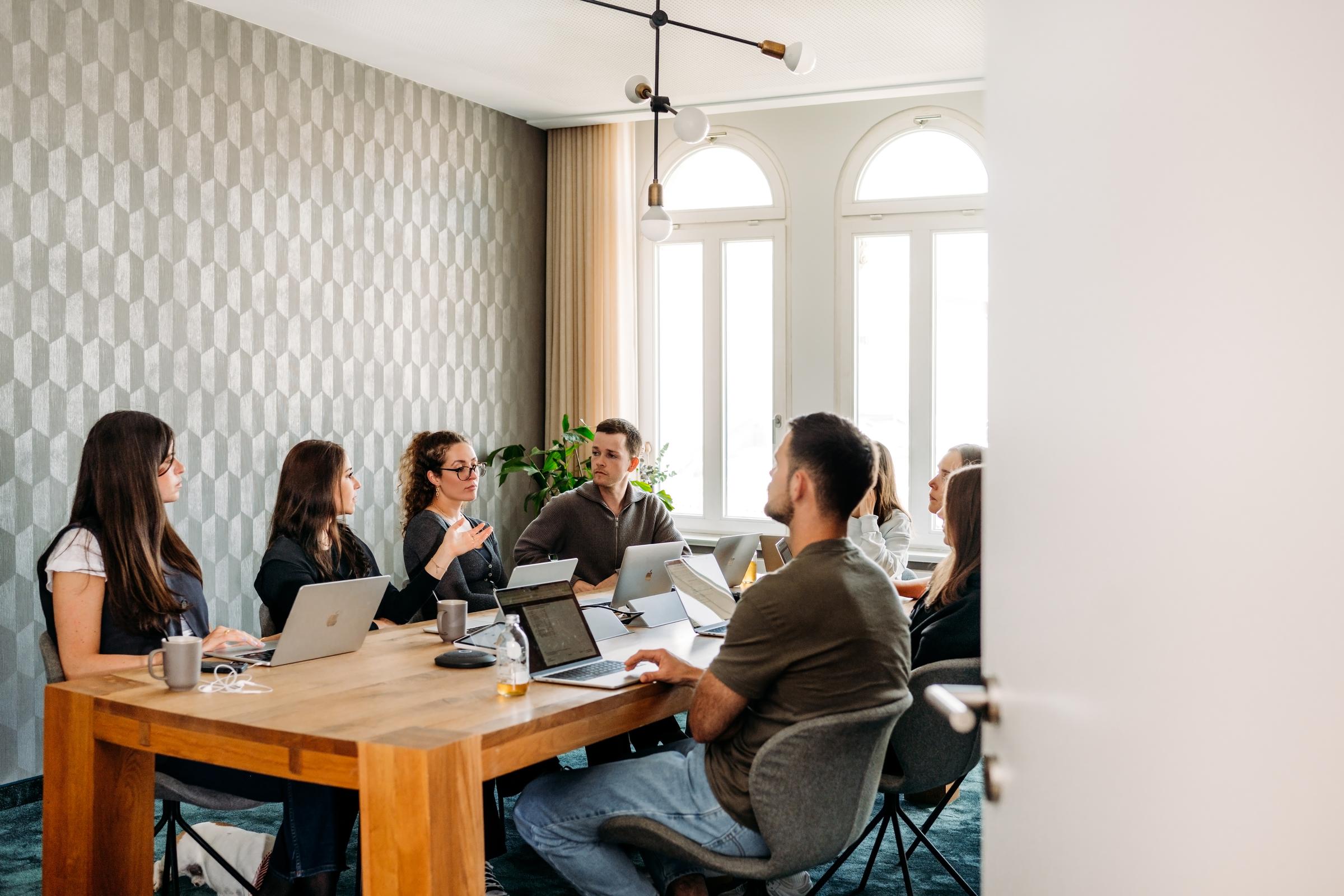 Ett mötesrum med människor runt ett bord