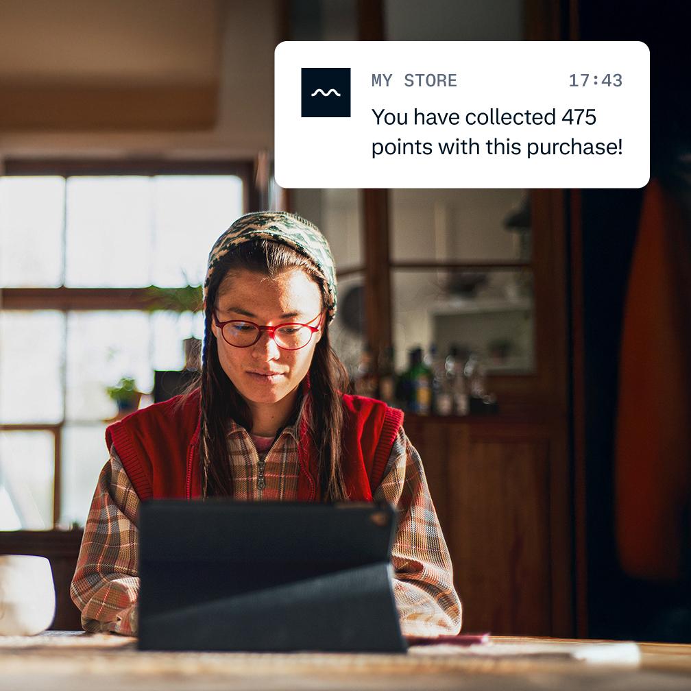 Guy looking at his iPad and notification of the points collected with his purchase