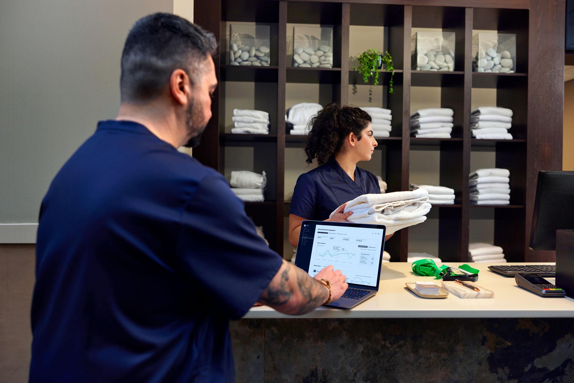 Spa employee looking at a Adyen dashboard with data charts.