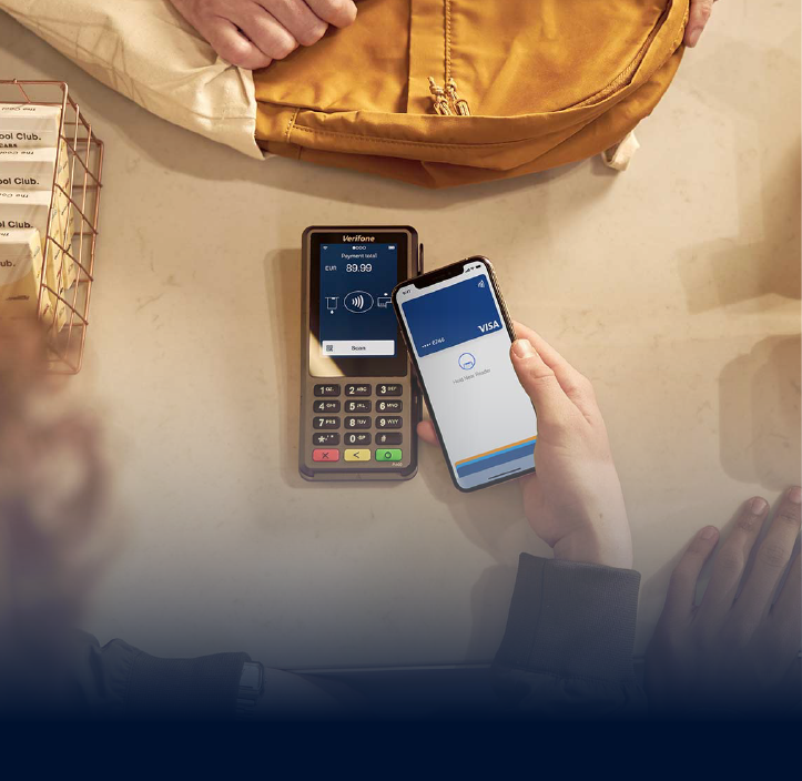 Um cliente paga com o telefone com cartão VISA no terminal da Adyen