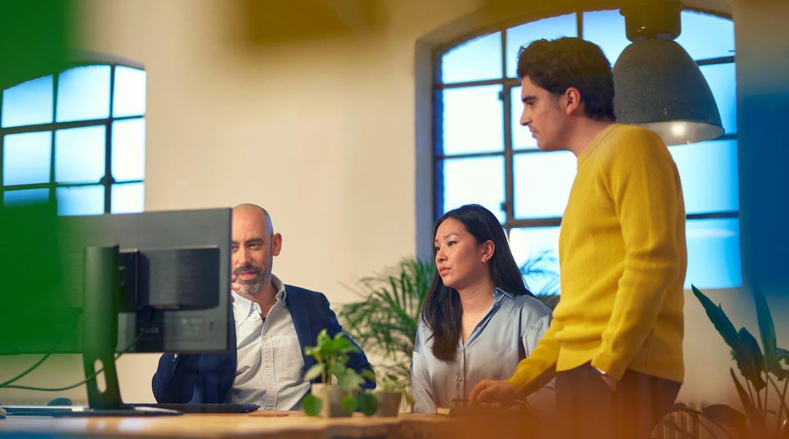 Three people looking at a screen and creating accounts