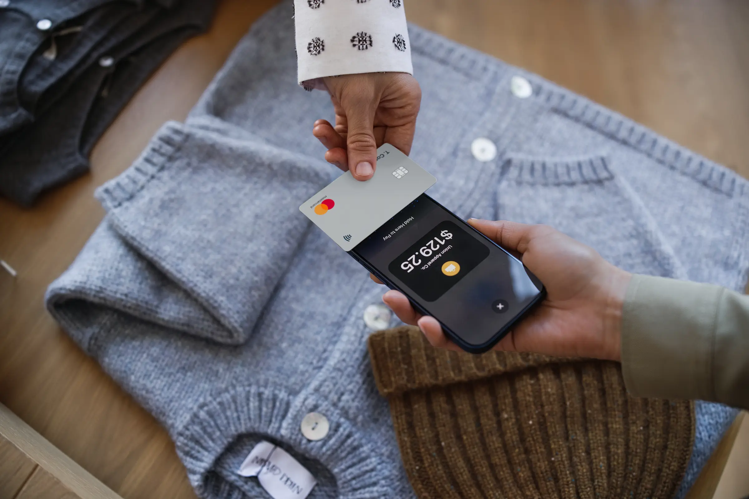 A person makes a payment using a mobile device and a contactless card with Adyen.