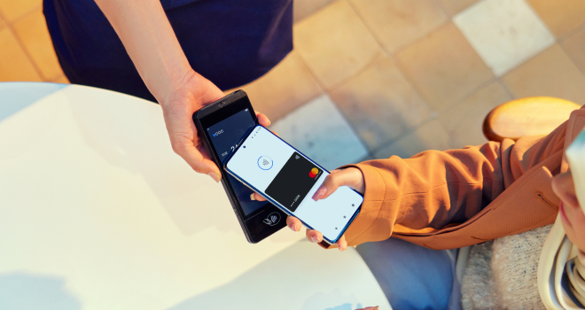 Dos personas realizando un pago móvil utilizando una billetera digital en el terminal S1E2L de Adyen.