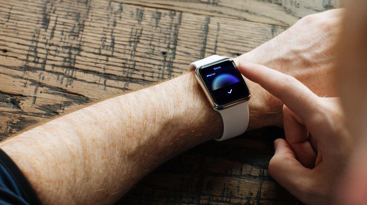 Primeiro plano de um dispositivo vestível no pulso mostrando uma tela de confirmação de pagamento digital