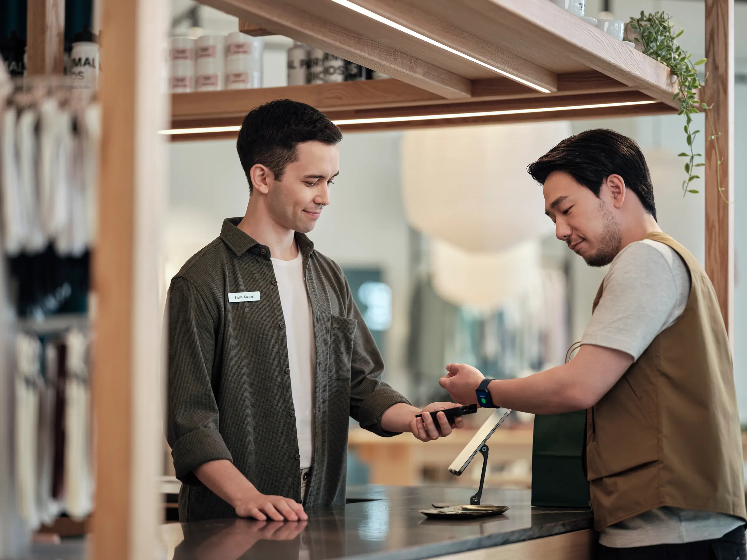 Asian guy paying with smart watch at counter