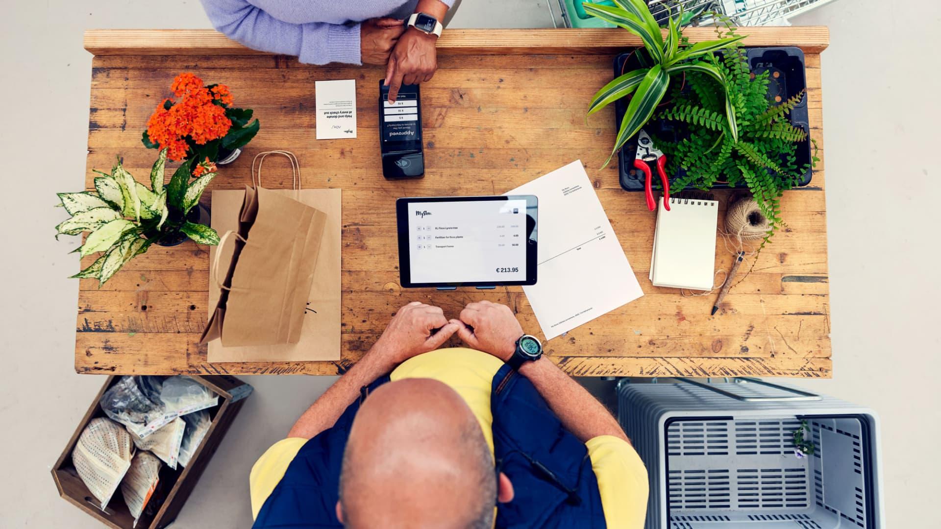 Top view of a person making a payment using a mobile device with Adyen's point of sale system.
