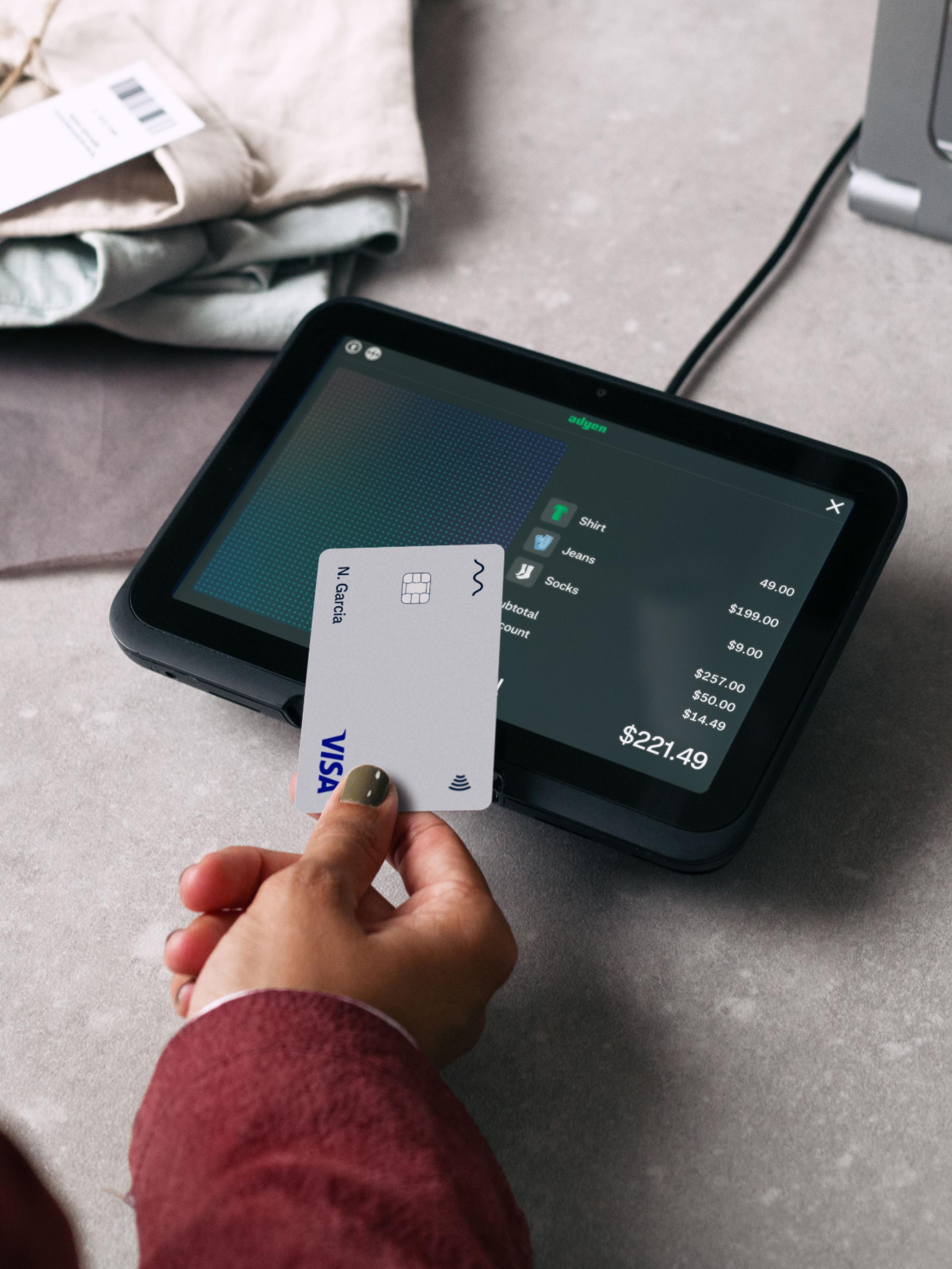 Person using a credit card on an Adyen point of sale terminal.