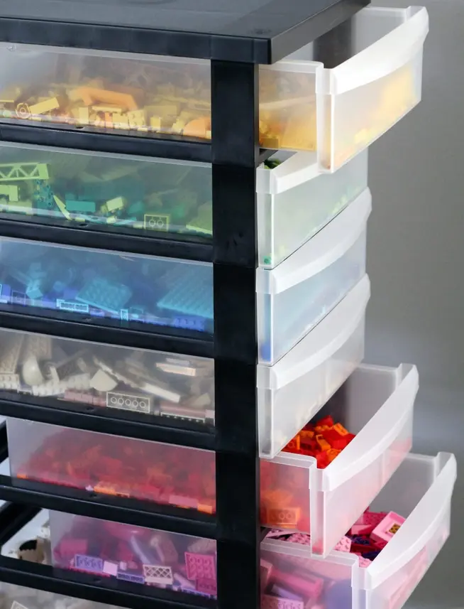 A set of transparent drawers filled with assorted colorful Lego bricks.