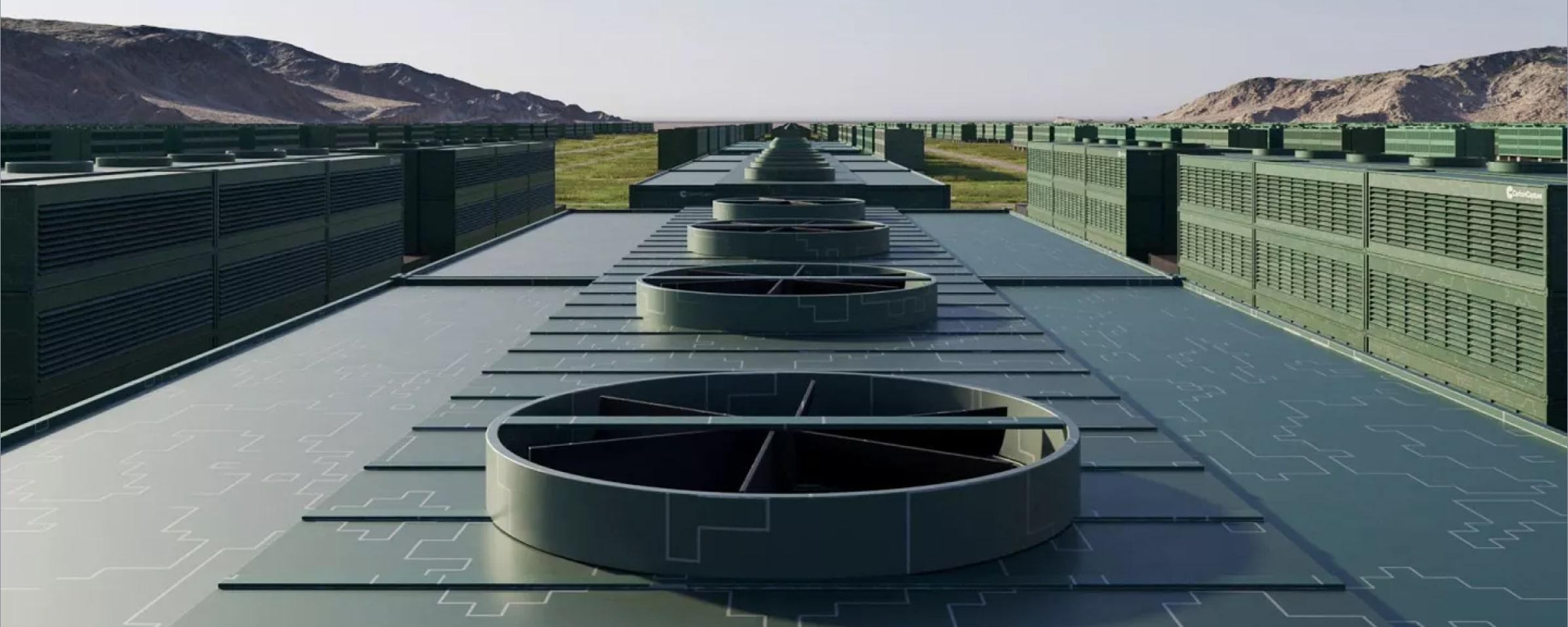 Rooftop with large circular vents and green industrial machinery against a mountainous backdrop.