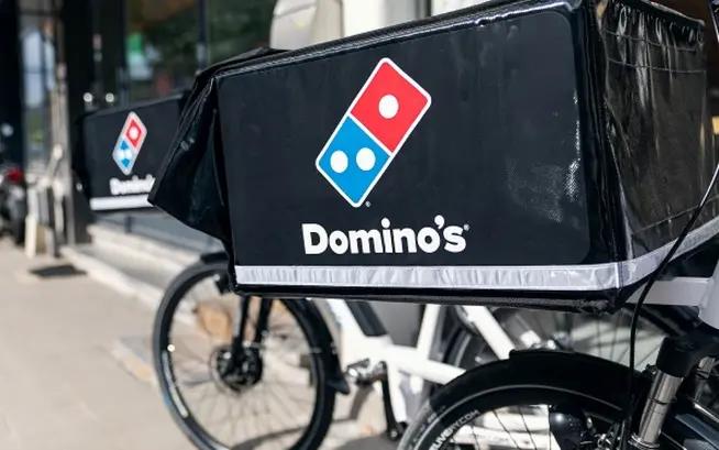 Domino's branded delivery bike parked on a city street.