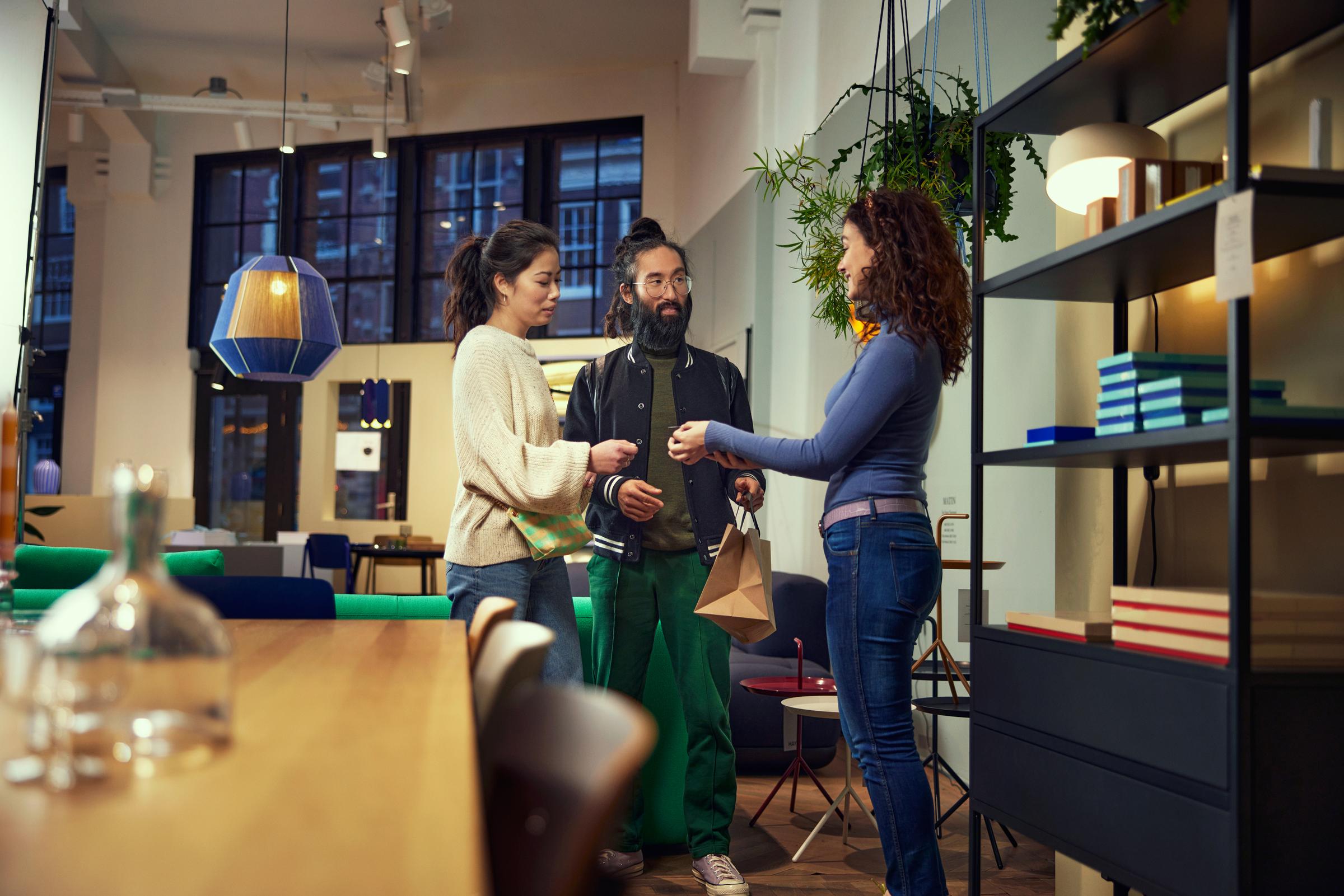 Uomo e donna che discutono con un commesso in un negozio di articoli per la casa e mobili