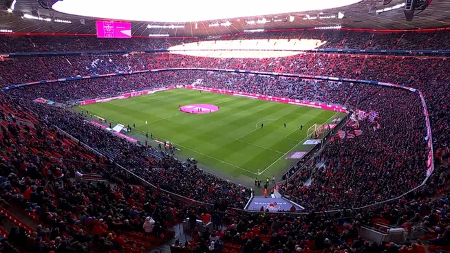 Weitwinkelaufnahme eines überfüllten Fußballstadions, in dem ein Spiel beginnen soll.