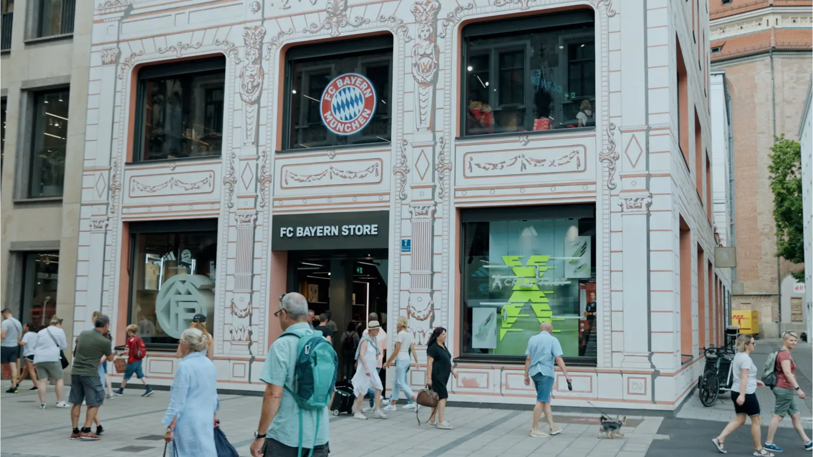 Piesi przechodzący obok sklepu FC Bayern Monachium z widocznym logo