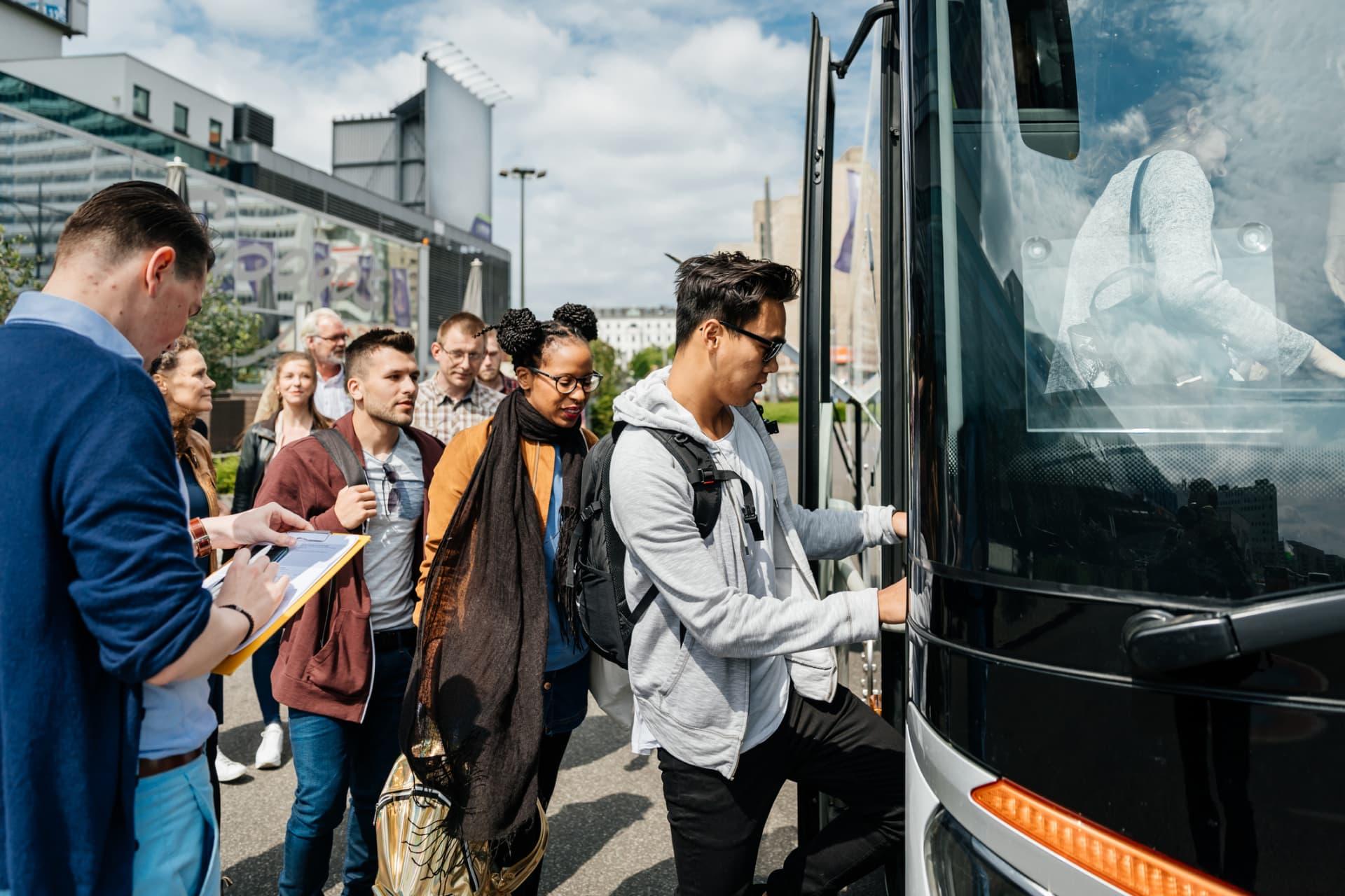 Group of people boarding a bus during daytime.