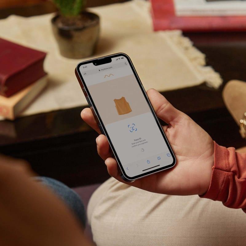 Person holding a smartphone displaying Adyen's online payment interface with a product image.