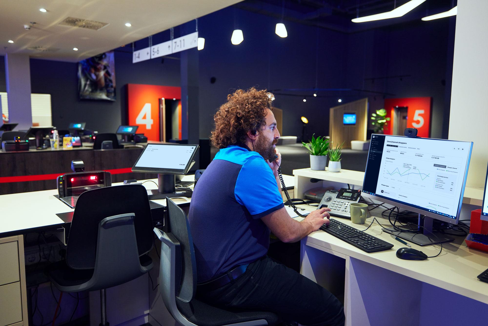 Un employé de cinéma regardant un tableau de bord omnicanal sur un moniteur.