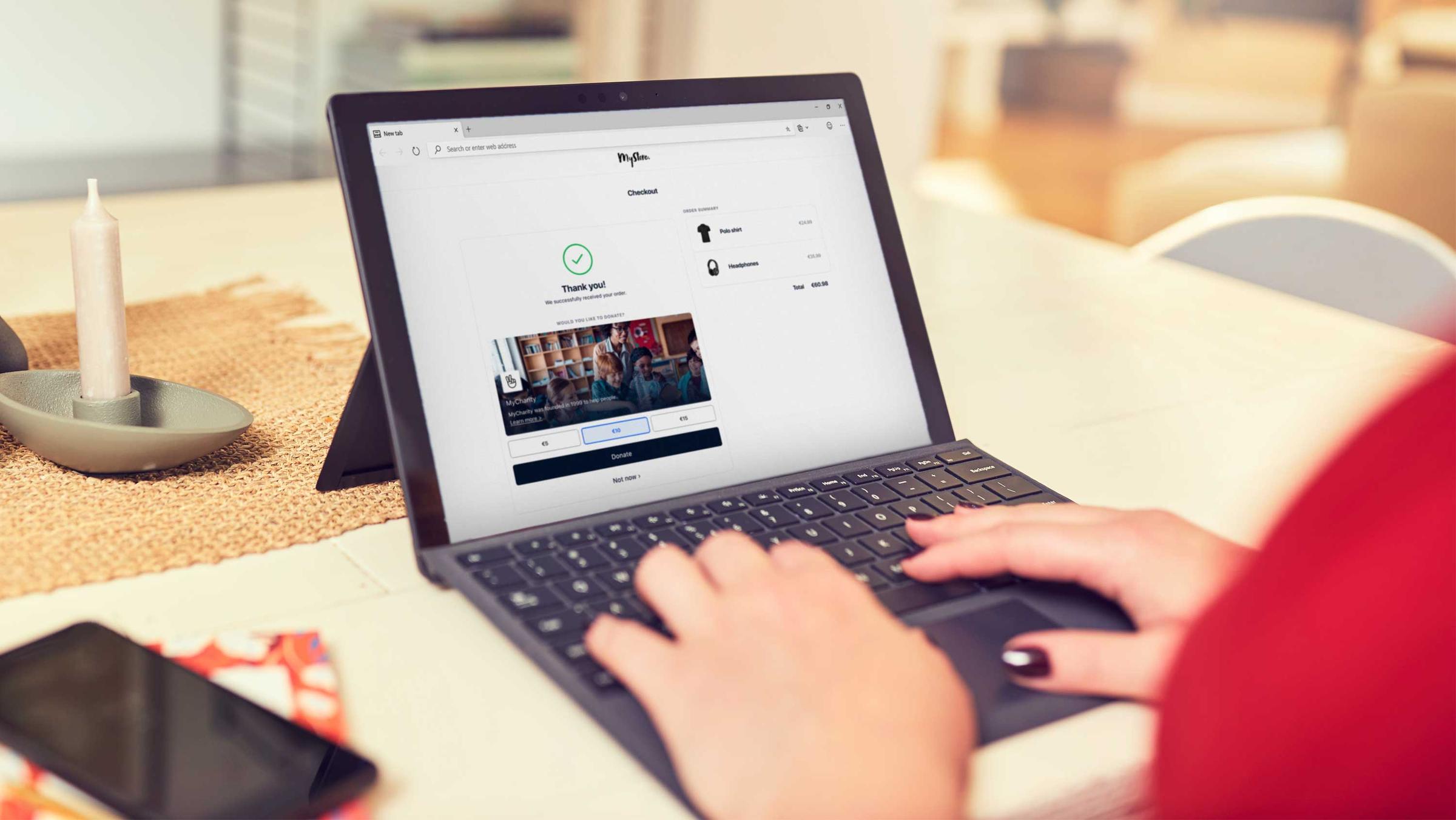 Person using a laptop displaying Adyen checkout page with a 'Thank you' message