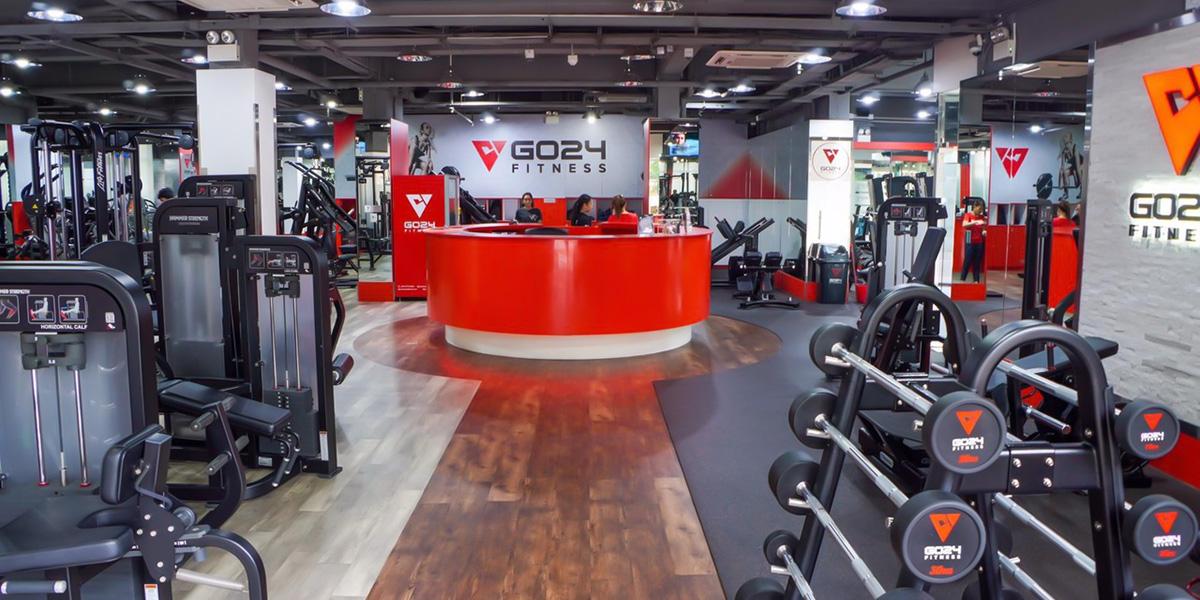 Interior view of GO24 Fitness gym with equipment and reception desk.