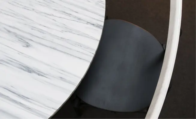 Vue aérienne d'une table en marbre élégante avec une chaise moderne partiellement enfoncée.