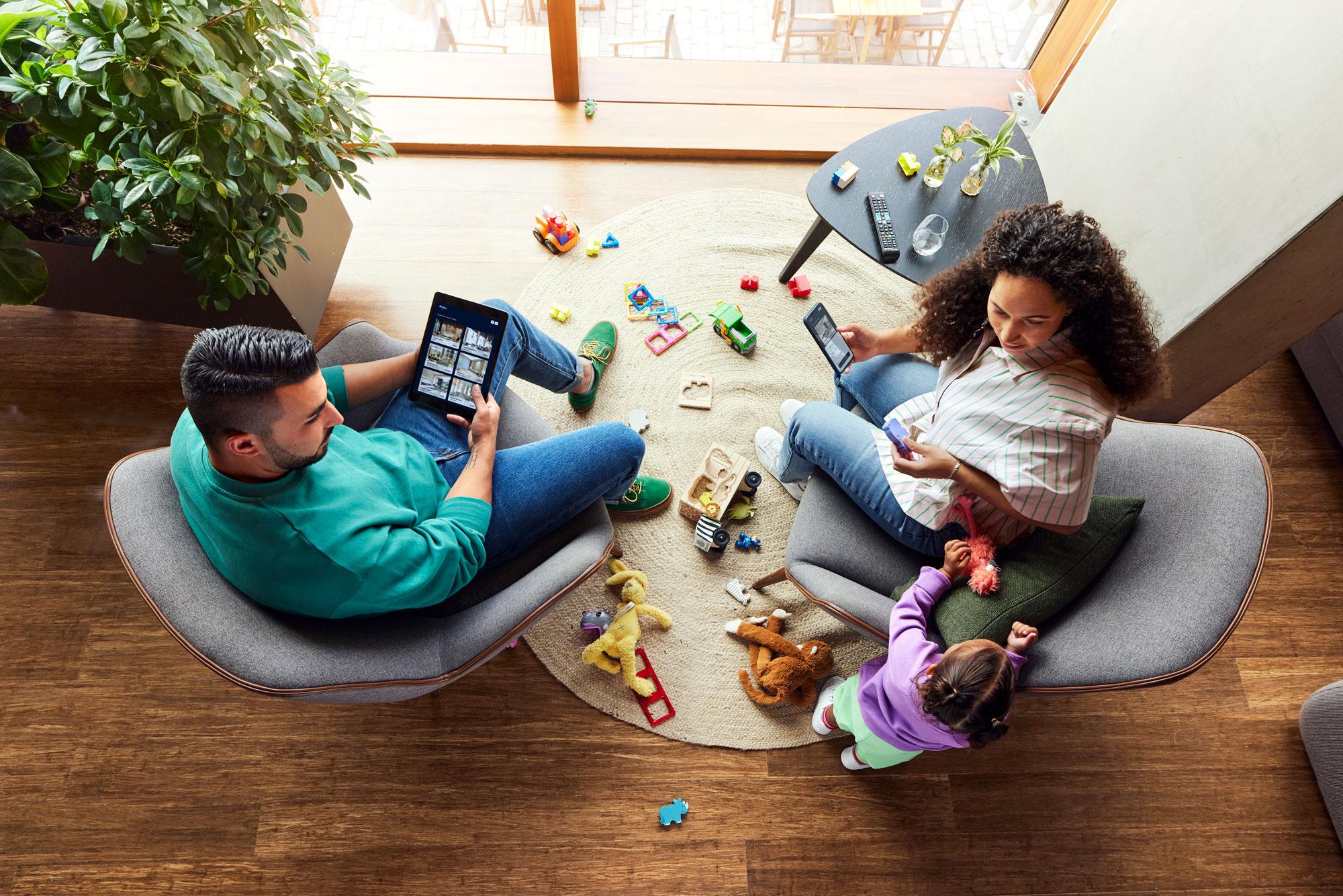 Een gezin met een kind boekt hun hotelverblijf op hun mobiele apparaten.