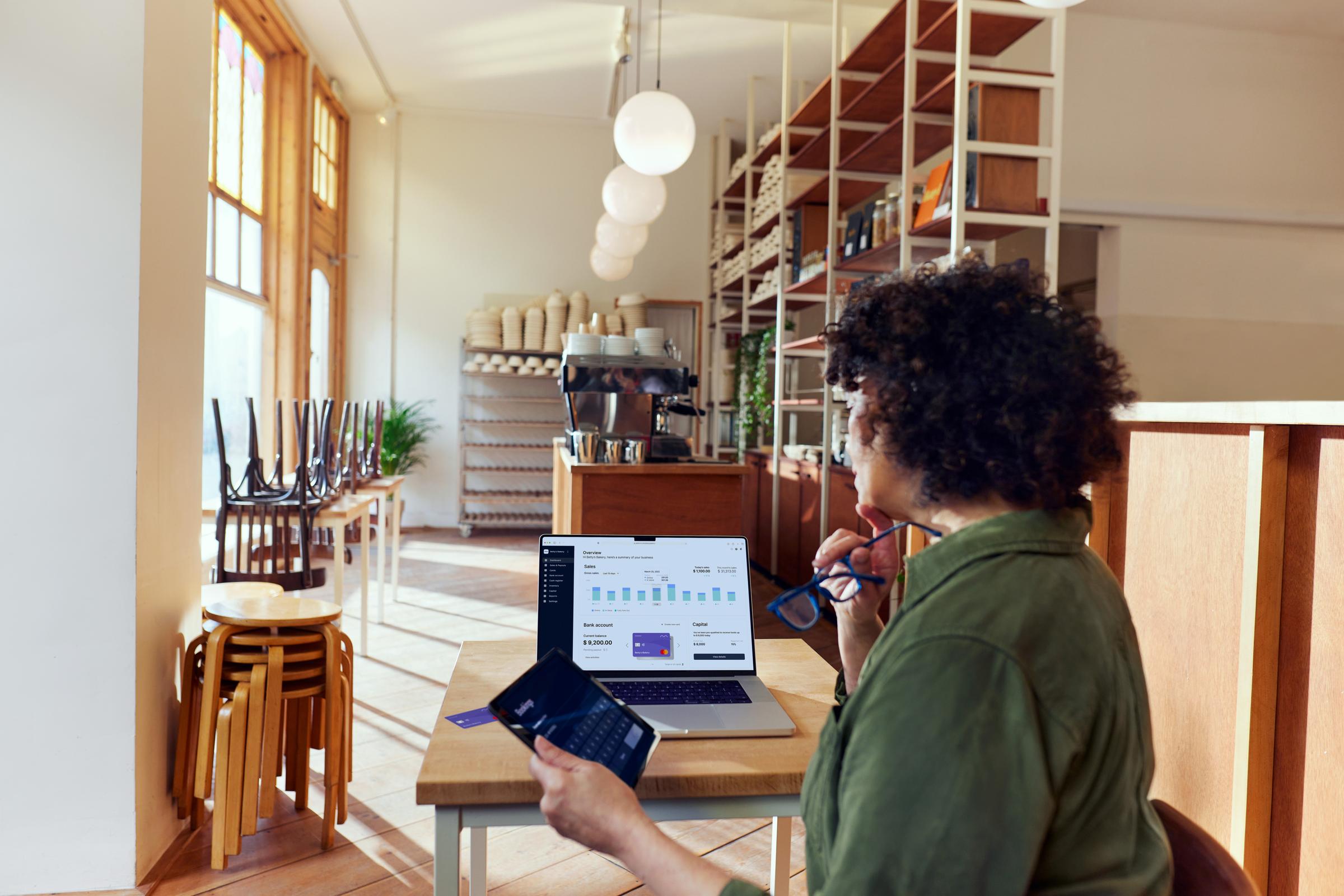 Coffee shop owner looking at their Adyen dashboard through a SaaS platform for food & beverage.