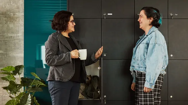 Adyen employees chatting in front of the lockers in an office.
