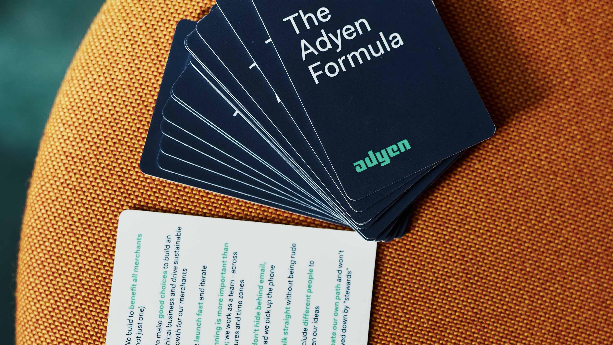 Pilha de cartões Adyen Formula aberta com um cartão exibindo texto.