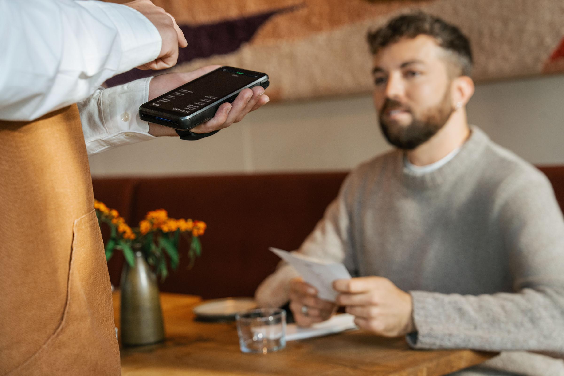 Person filling in order on Adyen terminal at a restaurant