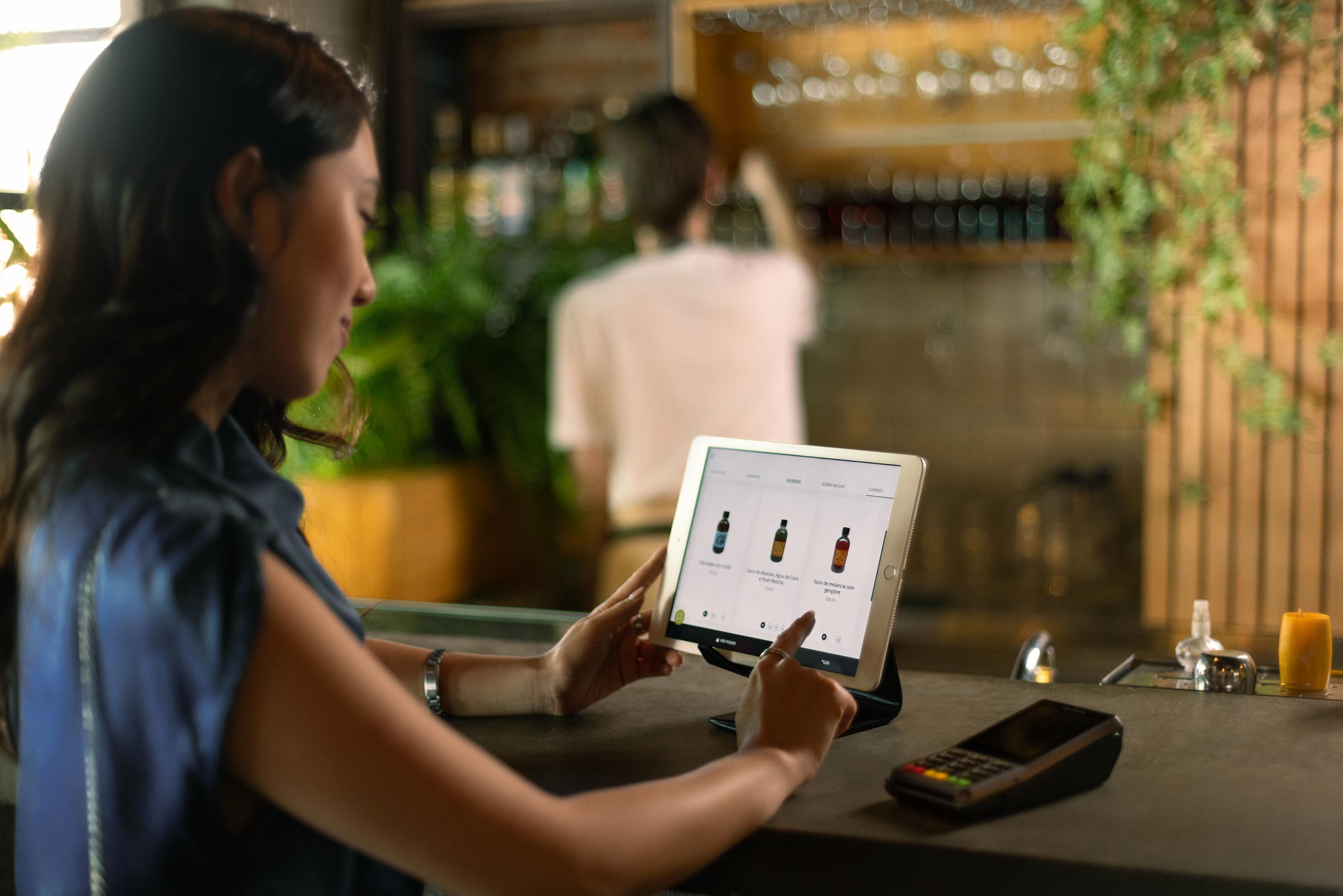 Mulher pagando em totem de autoatendimento