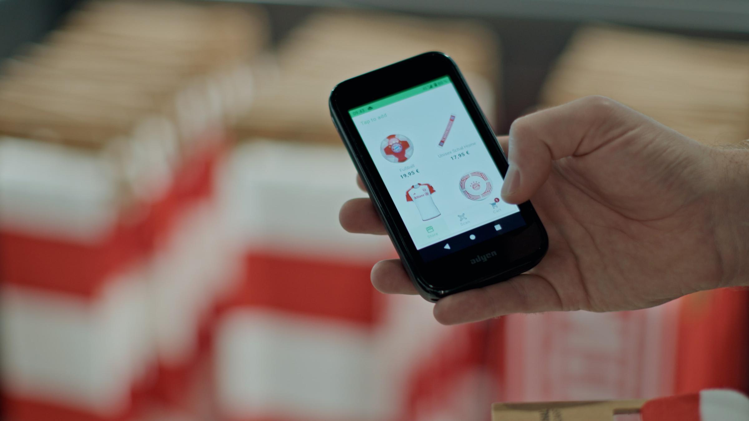 Hand holding a smartphone displaying Adyen's retail mobile app interface with product options.