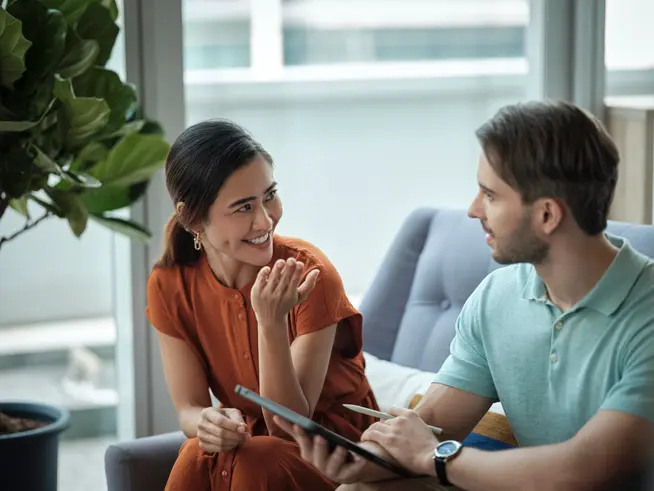 Nahaufnahme einer Frau und eines Mannes, die auf einem Sofa sitzen und diskutieren