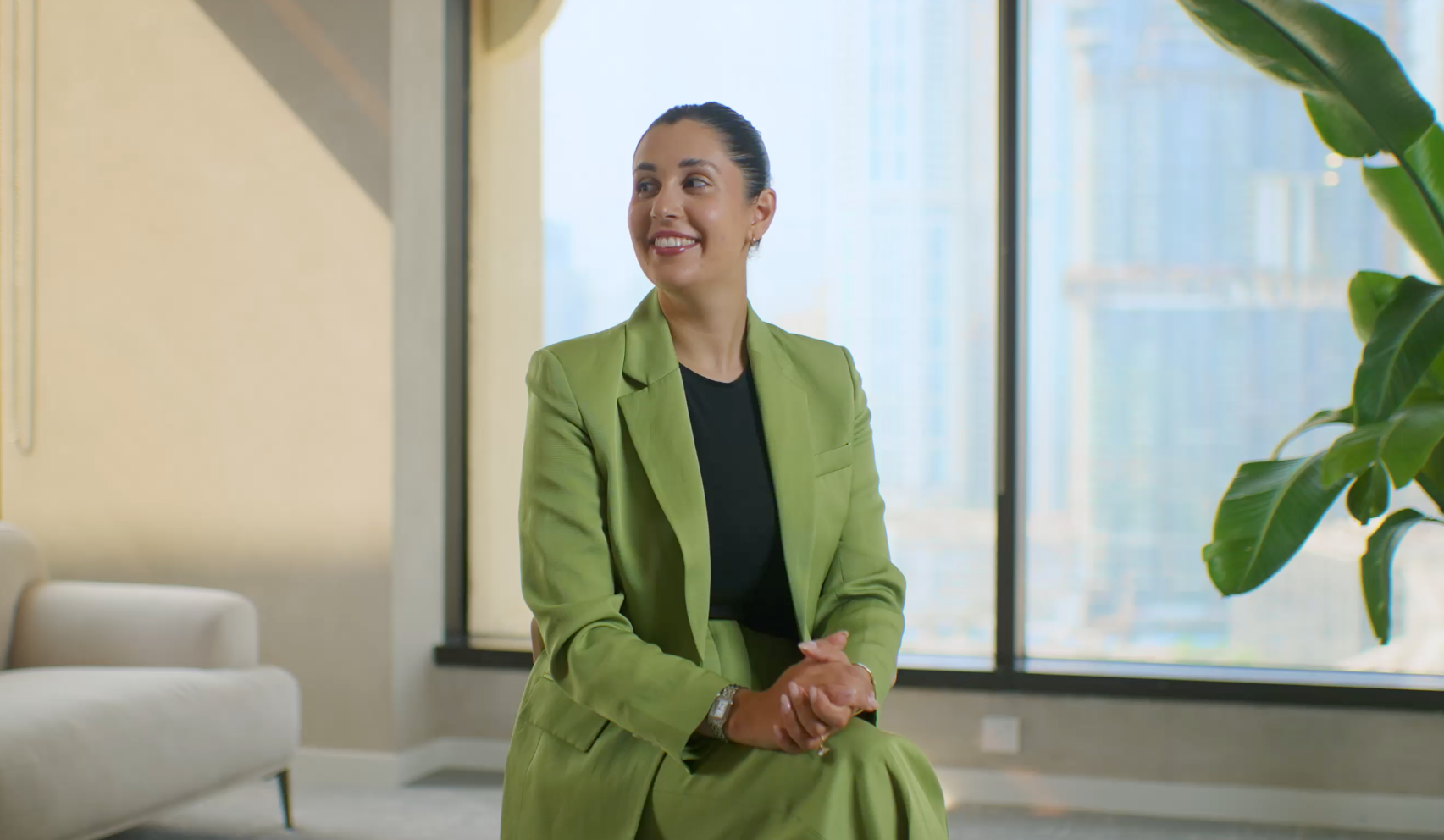 Adyen team member in a green suit in a modern office setting with large windows